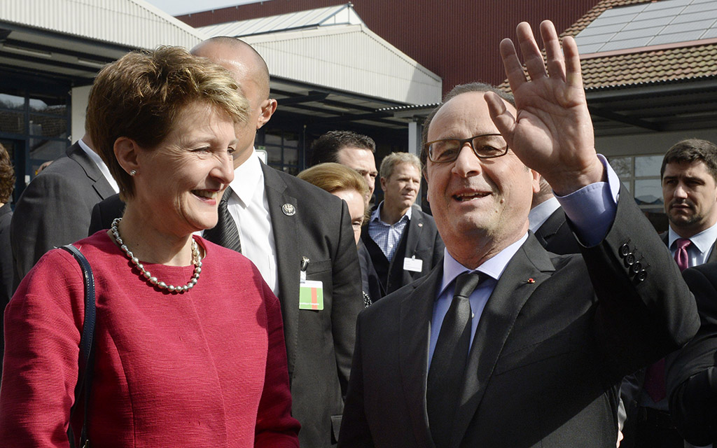 La presidente della Confederazione Simonetta Sommaruga e il presidente François Hollande salutano gli spettatori in occasione della visita della ditta Cleantech Ernst Schweizer AG di Hedingen ZH (Foto: Keystone)